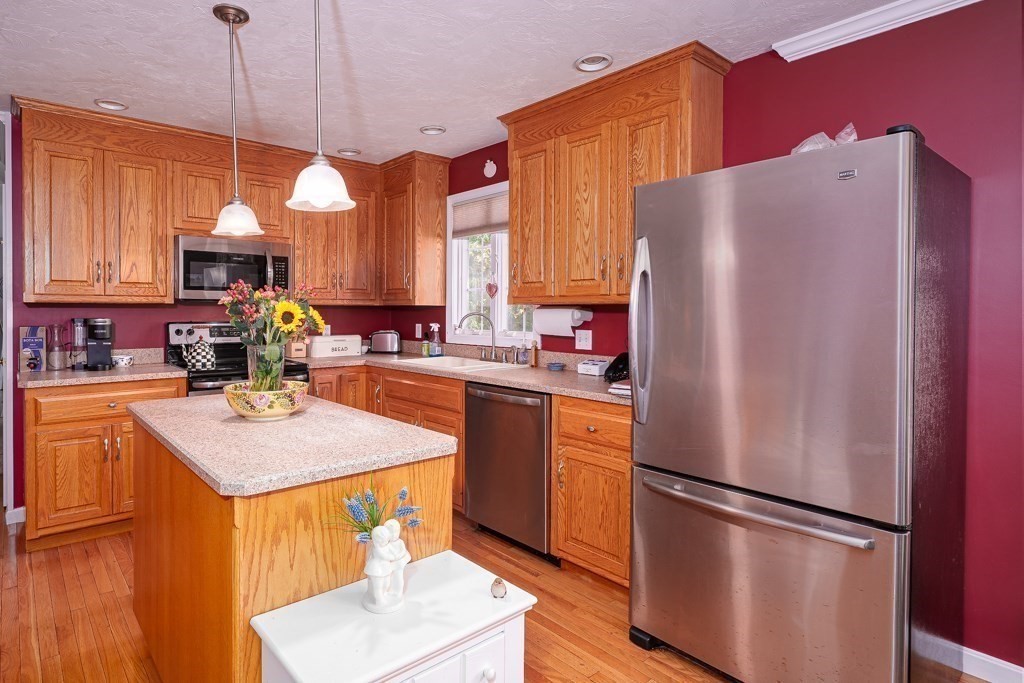 15 Fox Run Road, Unit 15 Blackstone, MA 01504 - Photo 5 of 22 a kitchen with stainless steel appliances granite countertop a refrigerator sink stove and white cabinets with wooden floor