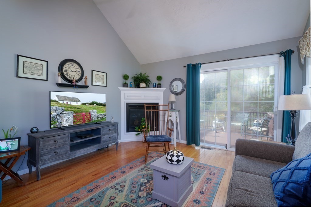 15 Fox Run Road, Unit 15 Blackstone, MA 01504 - Photo 10 of 22 a living room with furniture a flat screen tv and a floor to ceiling window