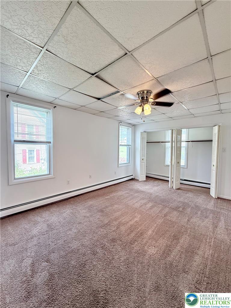 5540 Main Street Whitehall, PA 18052 - Photo 35 of 53 Primary bedroom features multiple windows for abundant natural light and soft carpeting.