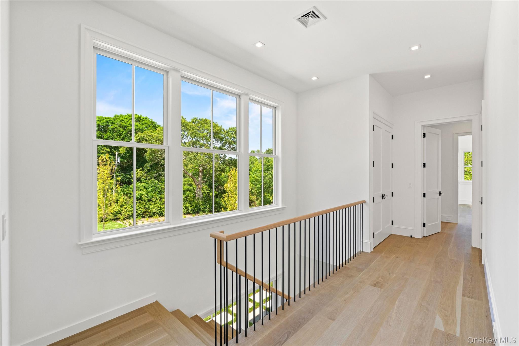 161 South Road Westhampton, NY 11977 - Photo 13 of 32 a view of a hallway to a bedroom with a window and wooden floor