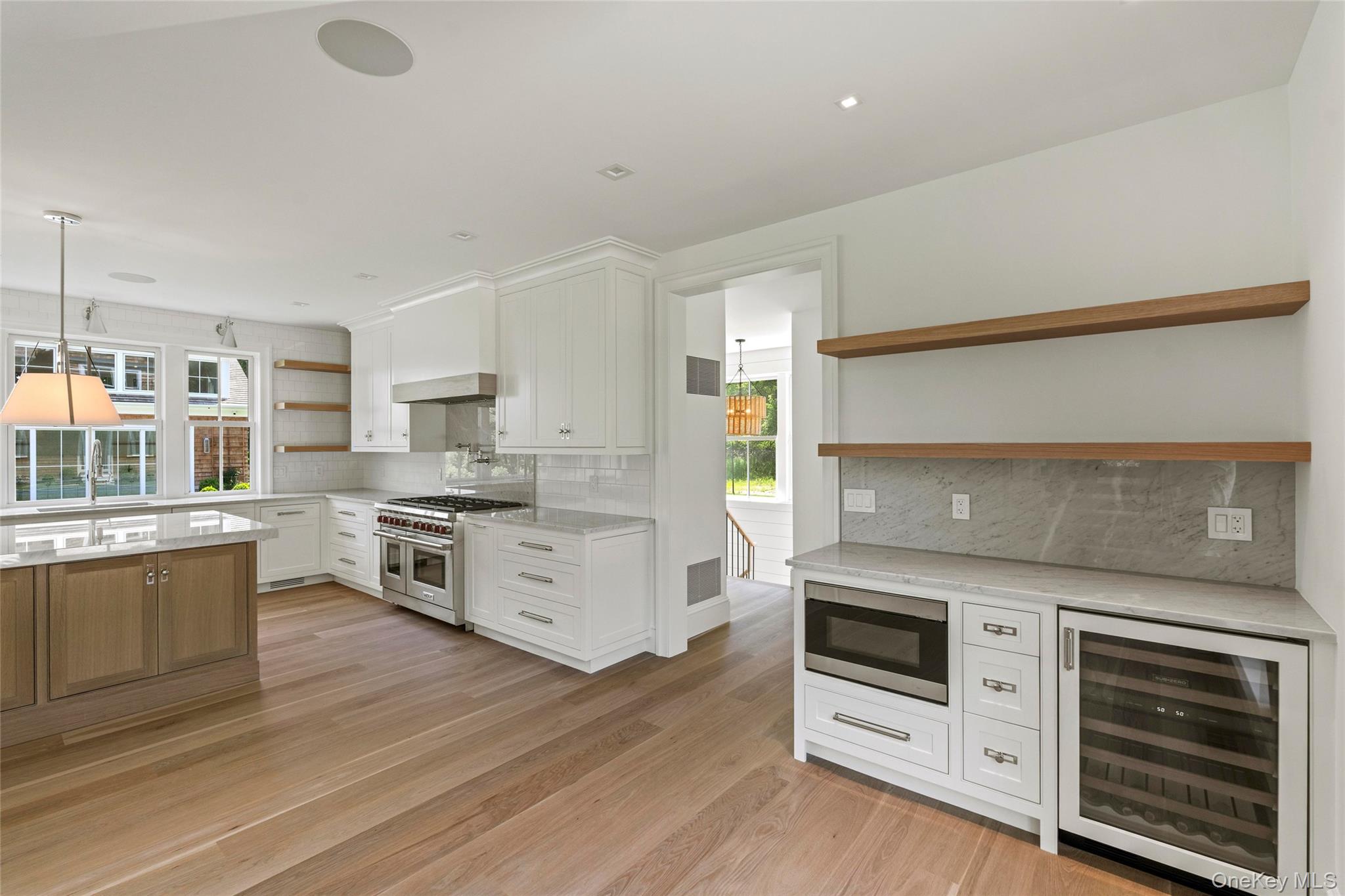 161 South Road Westhampton, NY 11977 - Photo 17 of 34 a kitchen with stainless steel appliances white cabinets and wooden floor