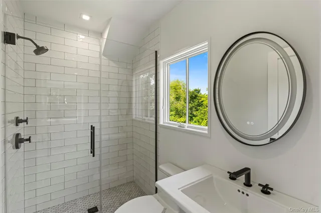 a bathroom with a sink a toilet and a mirror