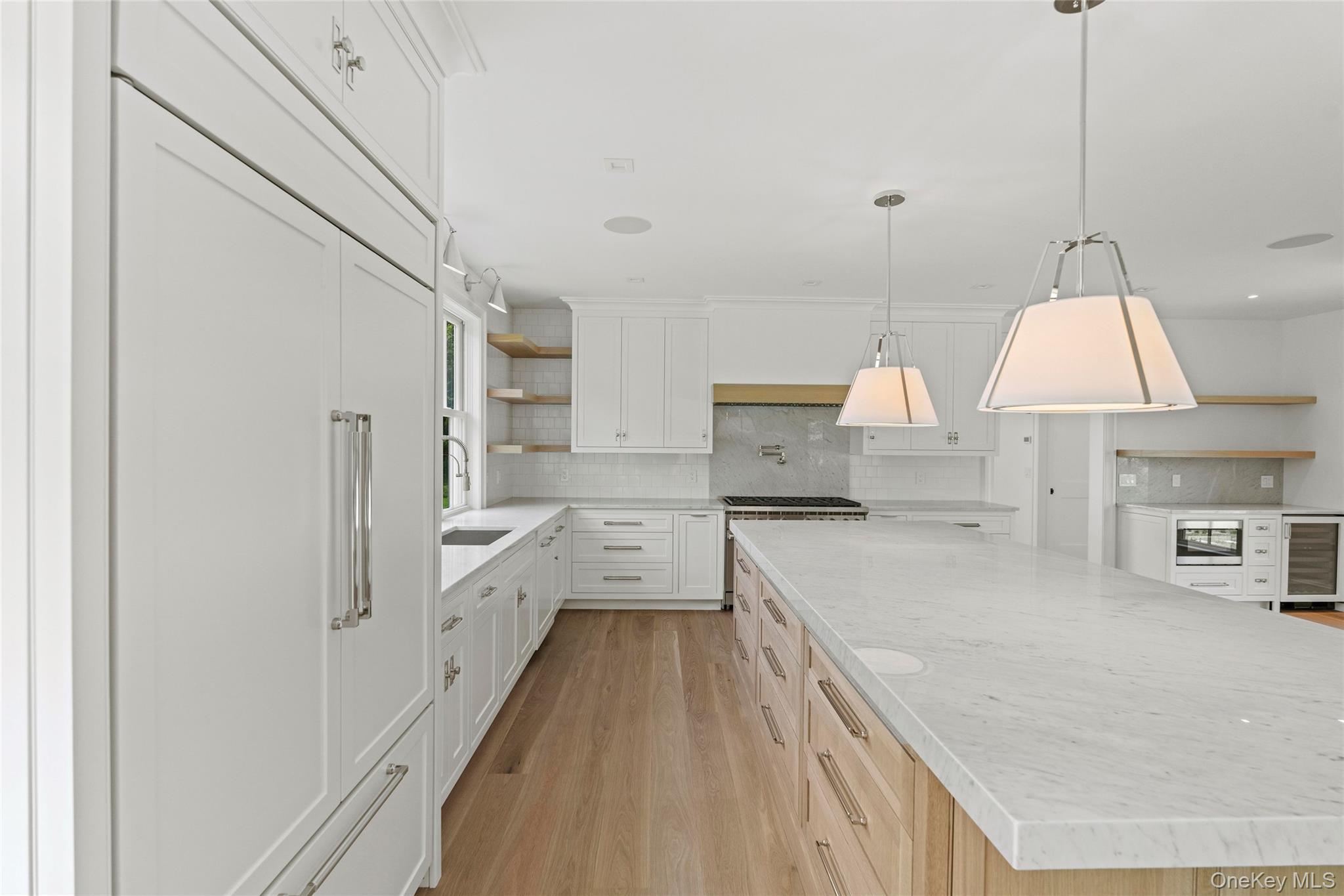 161 South Road Westhampton, NY 11977 - Photo 19 of 34 a large kitchen with stainless steel appliances a large counter top a stove a chimney a sink and a refrigerator