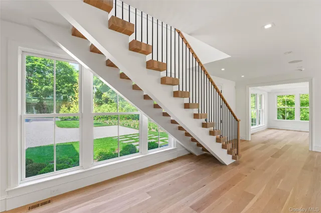 a view of staircase with wooden floor and white walls