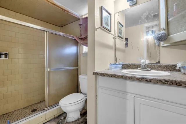 a bathroom with a granite countertop sink toilet and shower