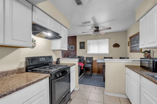 a kitchen with a stove cabinets and window