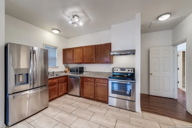 a kitchen with stainless steel appliances granite countertop a refrigerator stove and sink