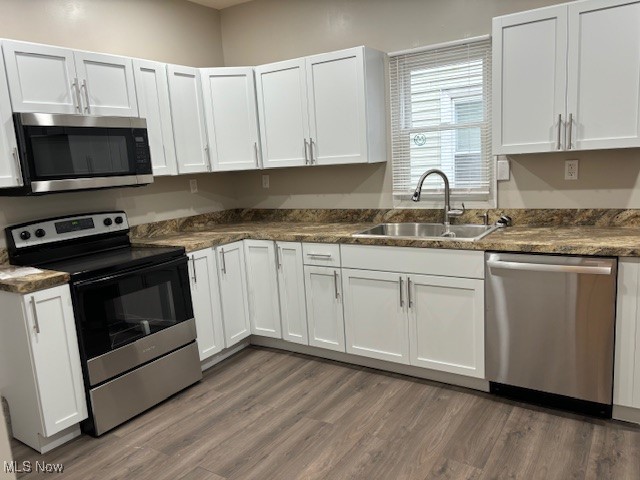 3721 Riverside Avenue Cleveland, OH 44109 - Photo 8 of 21 Kitchen featuring white cabinets, appliances with stainless steel finishes, dark hardwood / wood-style flooring, and sink