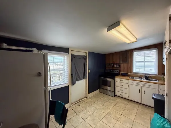 a kitchen with granite countertop a sink cabinets stainless steel appliances and a window