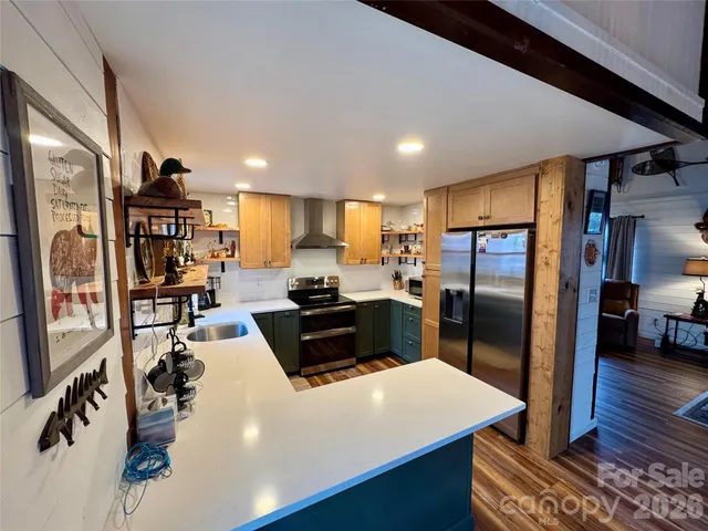 a kitchen with stainless steel appliances a refrigerator a sink a stove and a refrigerator