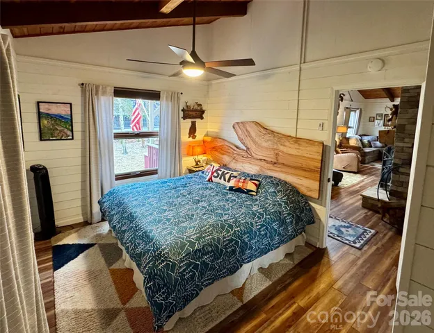 a bedroom with a bed and a flat tv screen on dresser