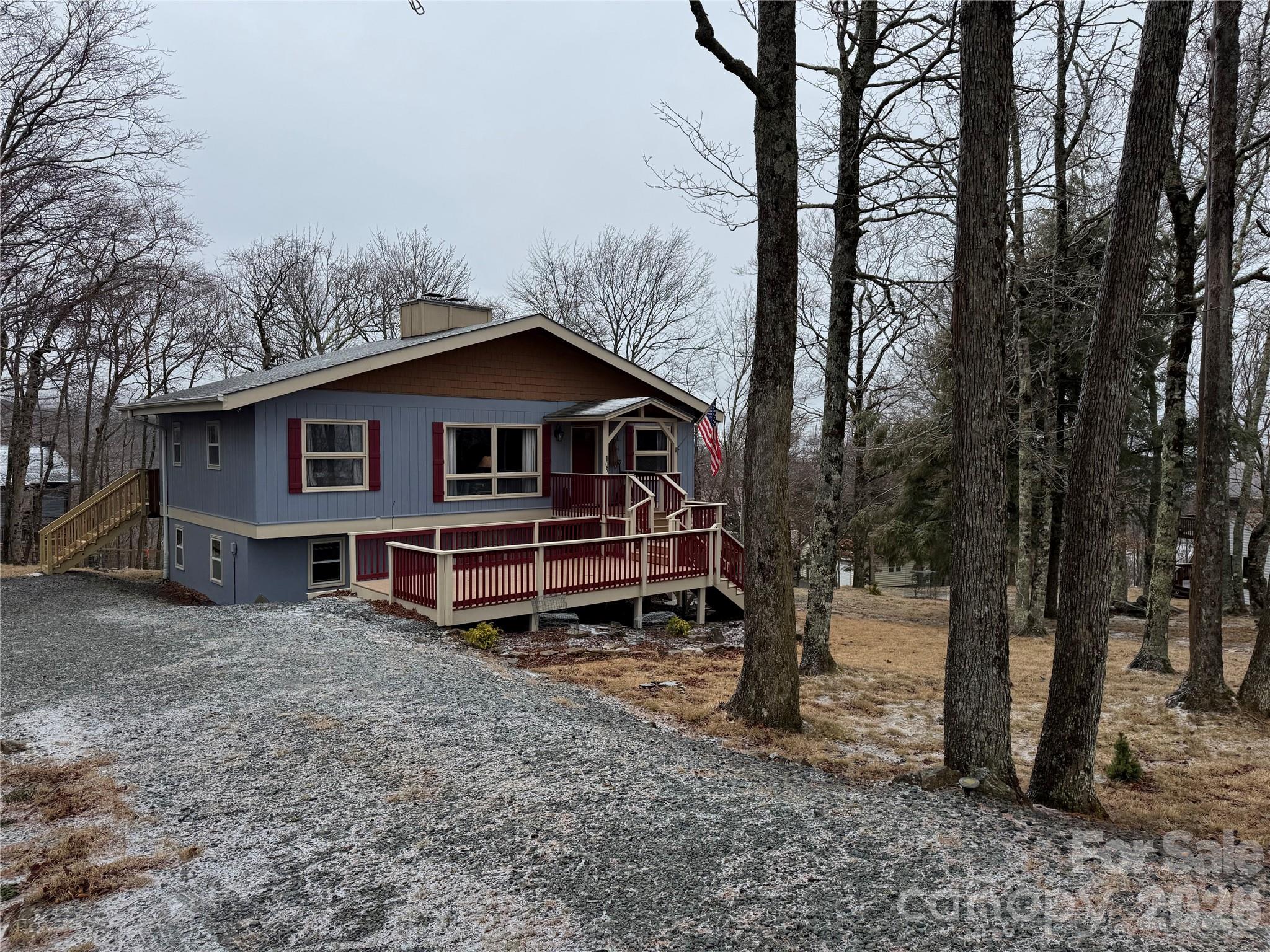 105 Pinnacle Ridge Road Beech Mountain, NC 28604 - Photo 2 of 38 a wooden house with large trees and wooden fence