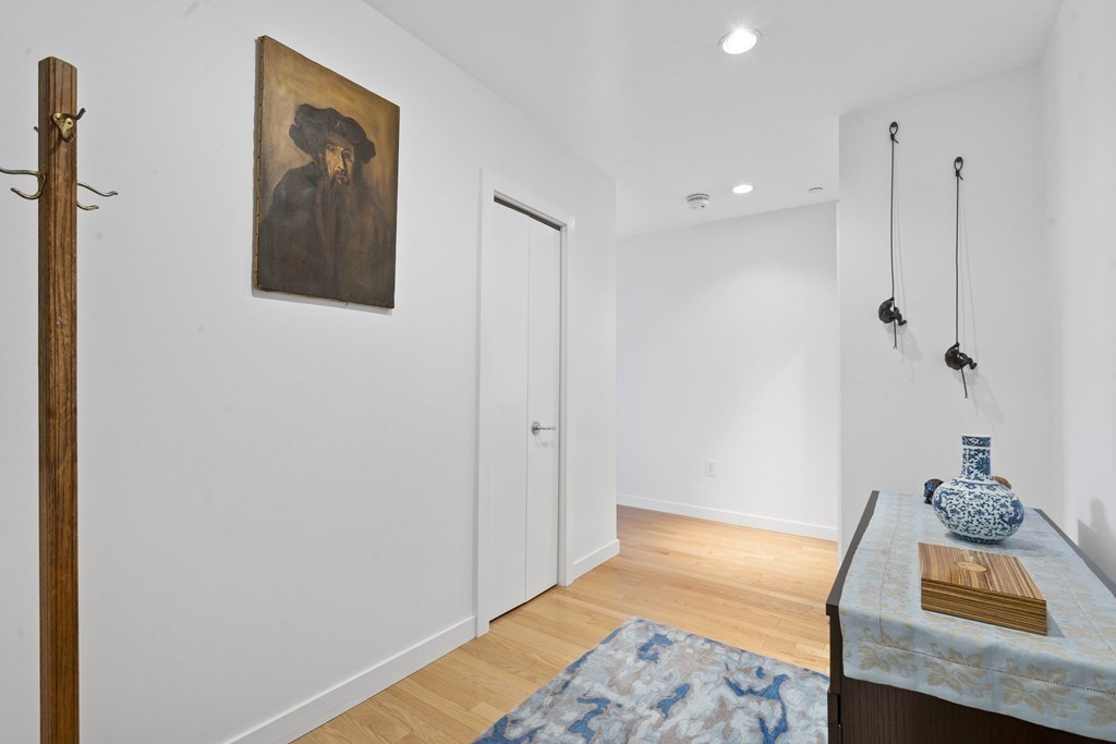 80 Broad Street, Unit 604 Boston, MA 02110 - Photo 14 of 21 a bedroom with a bed and a chandelier