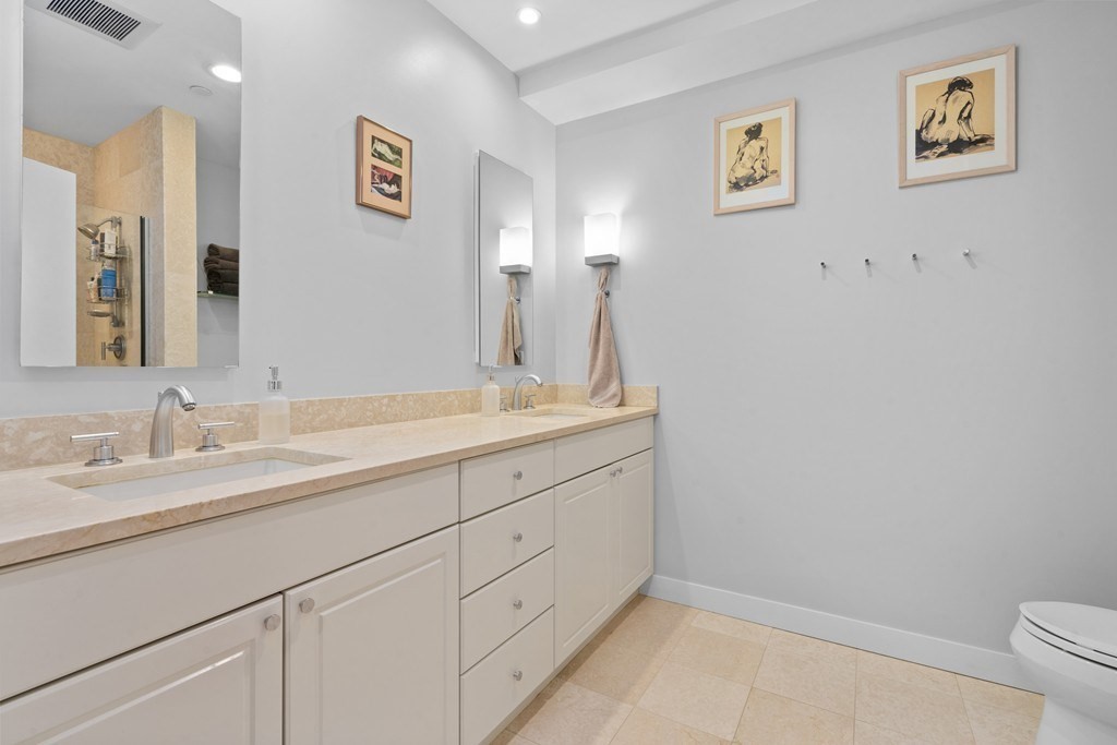 80 Broad Street, Unit 604 Boston, MA 02110 - Photo 7 of 21 a bathroom with a granite countertop sink mirror and toilet