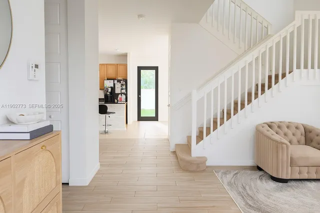 a view of entryway and hall with wooden floor