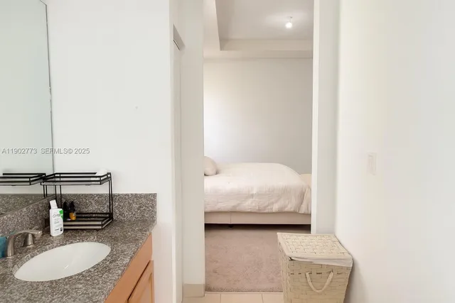 a en suite bathroom with a granite countertop sink and a mirror