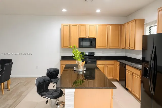 a kitchen with a sink appliances cabinets and furniture