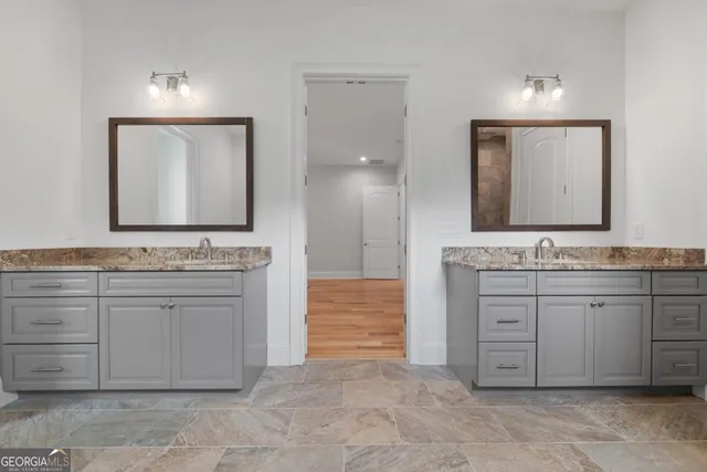 a bathroom with a granite countertop sink and a mirror
