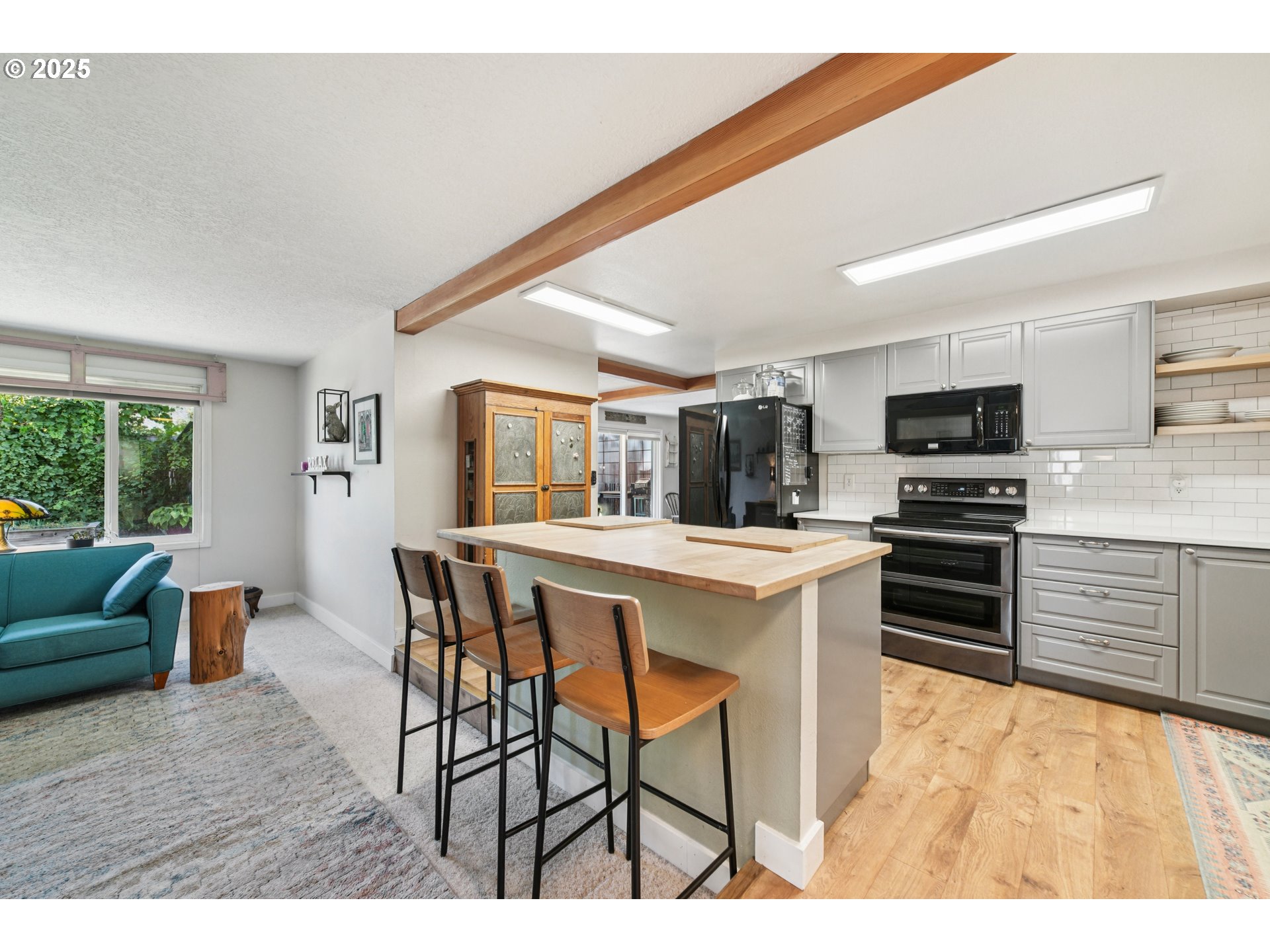 17226 Southwest Baker Street Beaverton, OR 97007 - Photo 11 of 34 a kitchen with a table chairs microwave and cabinets
