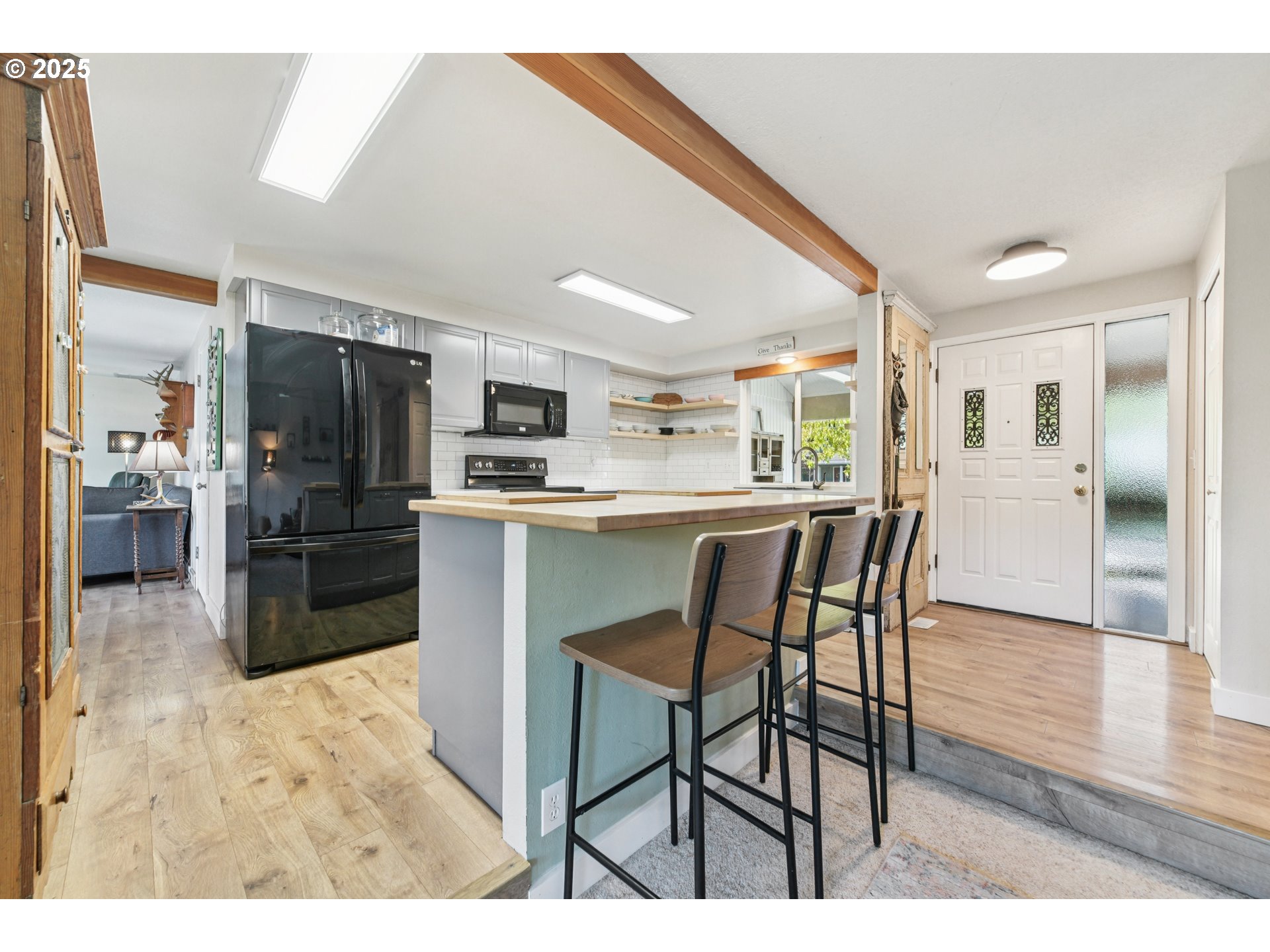 17226 Southwest Baker Street Beaverton, OR 97007 - Photo 15 of 34 a kitchen with stainless steel appliances kitchen island granite countertop a refrigerator and cabinets