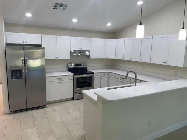 a kitchen with stainless steel appliances granite countertop a sink a stove a refrigerator and cabinets