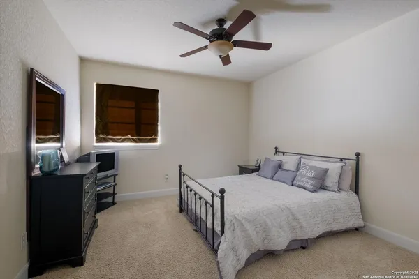 a bedroom with a bed and a flat tv screen on a dresser
