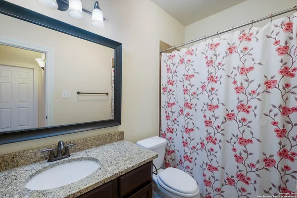 a bathroom with a granite countertop sink and a mirror
