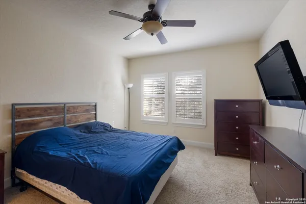 a bedroom with a bed and a flat tv screen on dresser