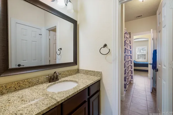 a bathroom with a granite countertop sink and a mirror