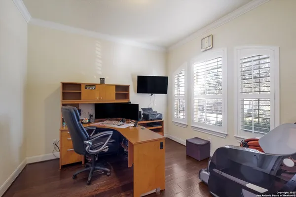 a view of a workspace with furniture and a window