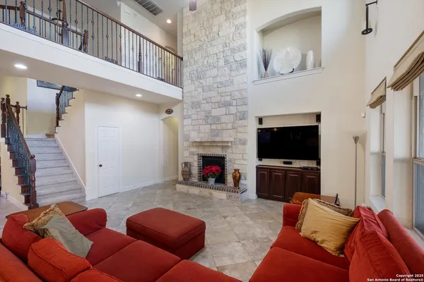 a living room with furniture a flat screen tv and a fireplace