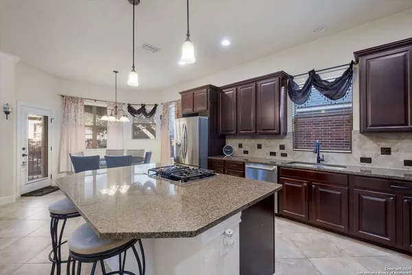 a kitchen with a stove a sink a dining table and chairs