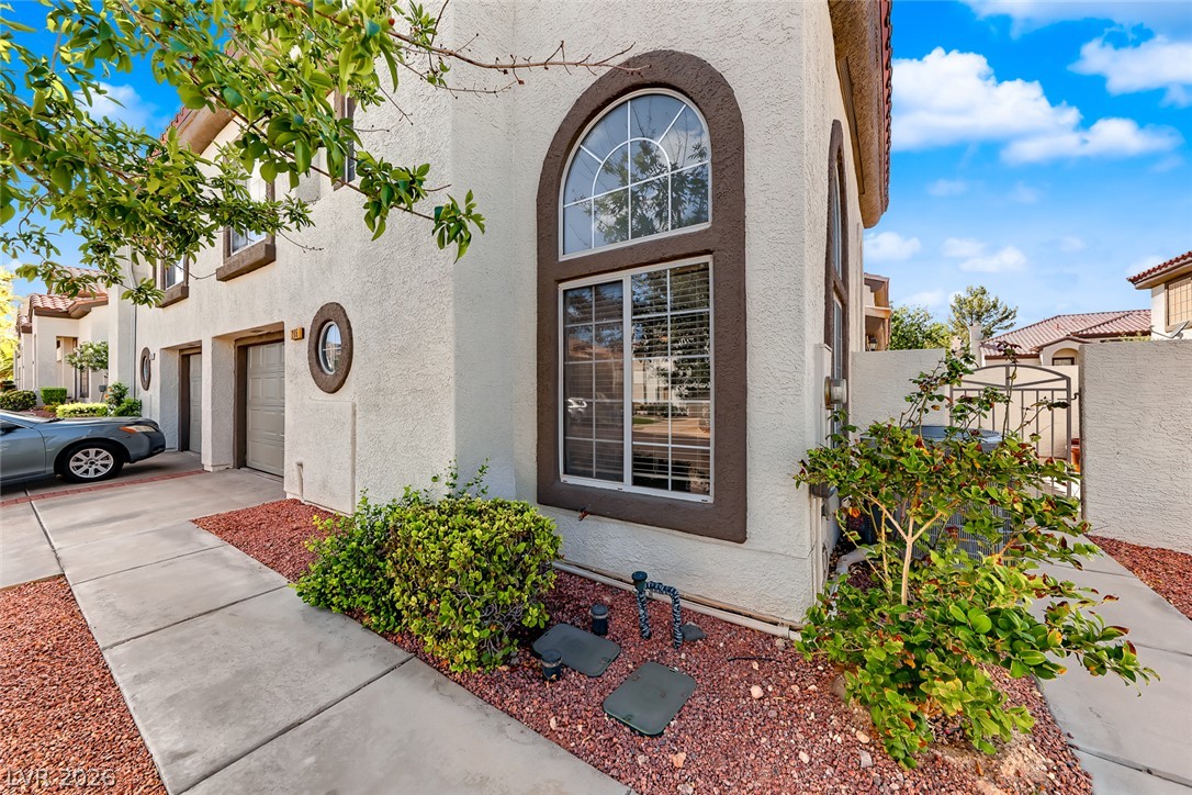 205 Genesee Point Street Henderson, NV 89074 - Photo 3 of 30 Stucco walls and arched window details elevate the exterior architecture of this multi-level home.