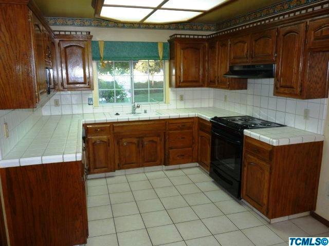 733 South Anderson Road Exeter, CA 93221 - Photo 4 of 17 a kitchen with a sink a stove cabinets and a window