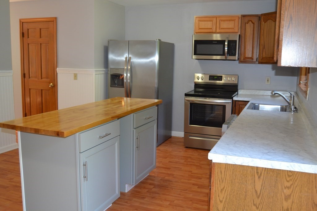 61 Monson Road Wales, MA 01081 - Photo 27 of 41 a kitchen with stainless steel appliances granite countertop a sink stove and refrigerator