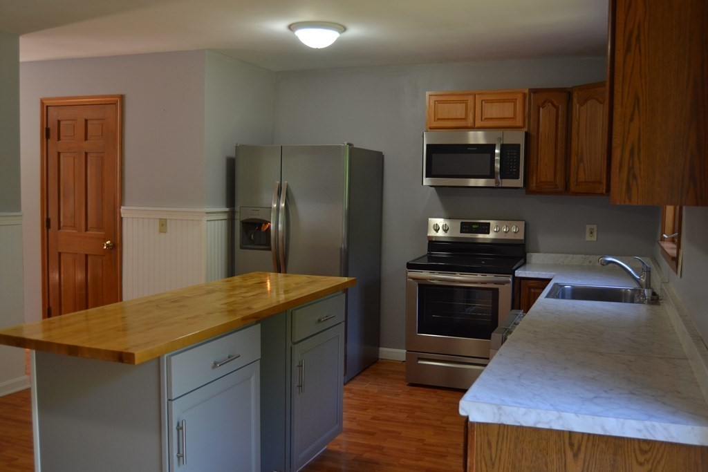 61 Monson Road Wales, MA 01081 - Photo 28 of 41 a kitchen with stainless steel appliances granite countertop a stove refrigerator and microwave