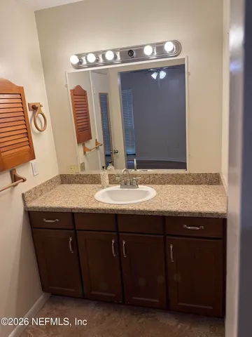 a bathroom with a granite countertop sink and a mirror