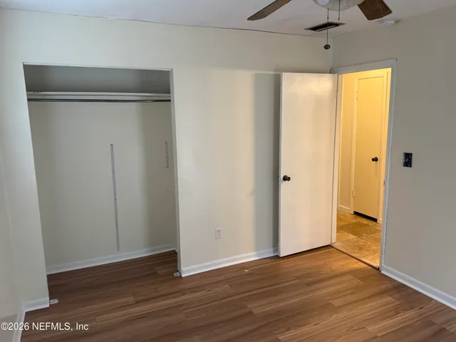 a view of an empty room with wooden floor