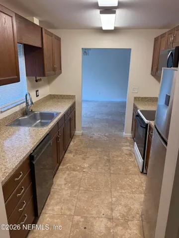 a bathroom with a granite countertop sink a toilet a mirror and vanity