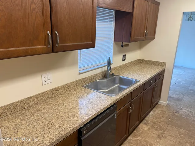 a kitchen with stainless steel appliances granite countertop a sink a stove and dishwasher