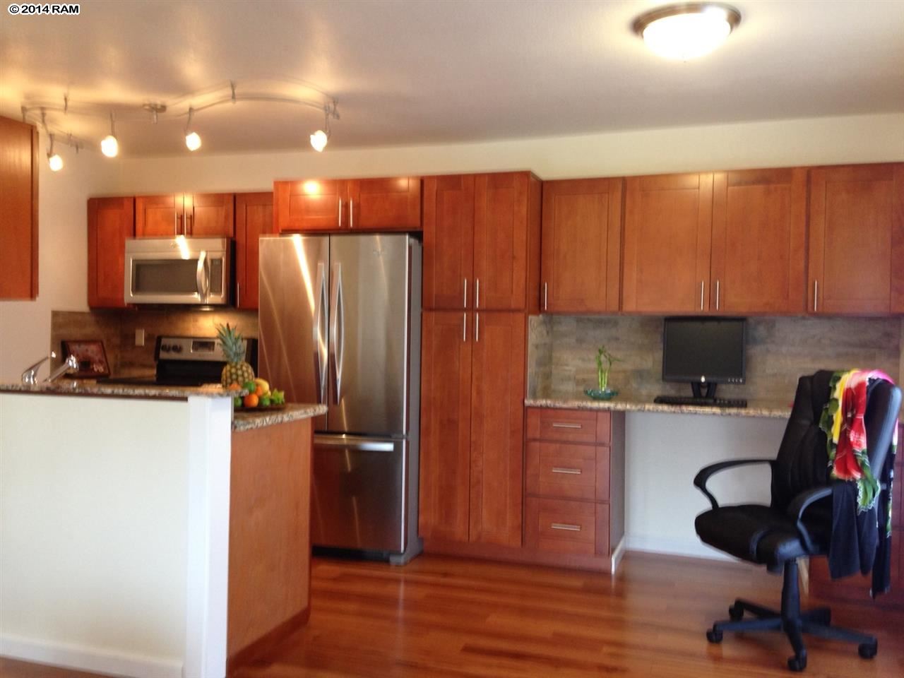 480 Kenolio Road, Unit 13204 Kihei, HI 96753 - Photo 1 of 18 a kitchen with wooden cabinets and refrigerator