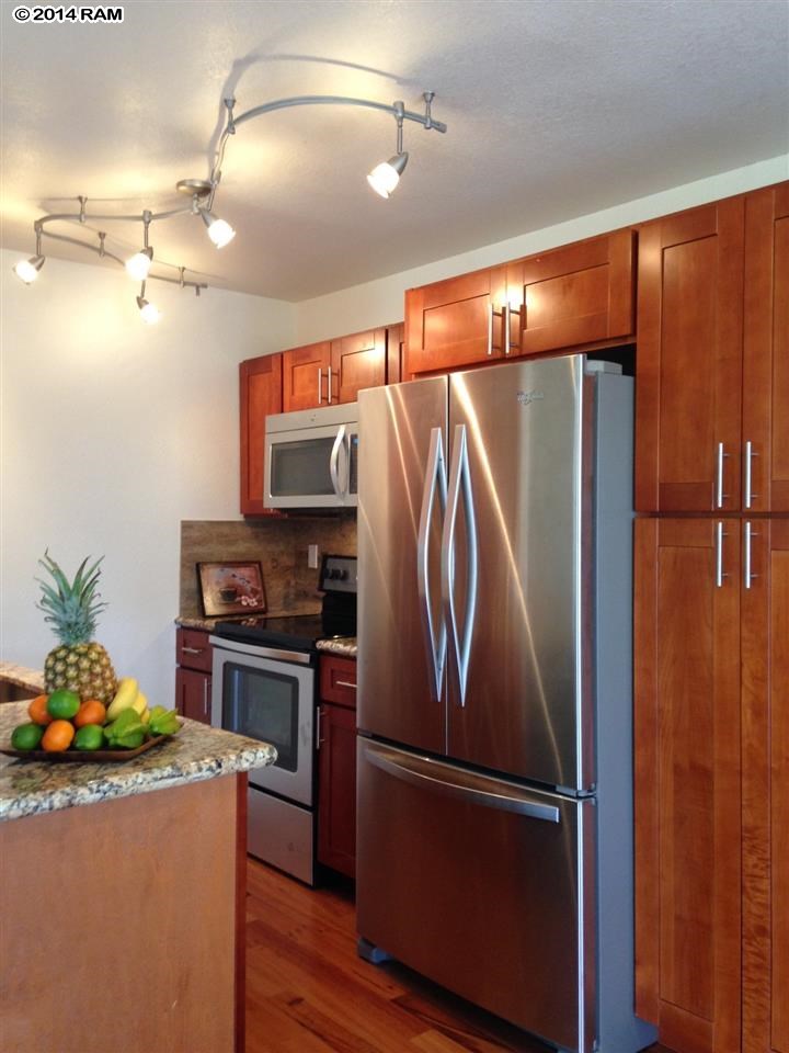 480 Kenolio Road, Unit 13204 Kihei, HI 96753 - Photo 4 of 18 a kitchen with stainless steel appliances granite countertop a refrigerator and a stove