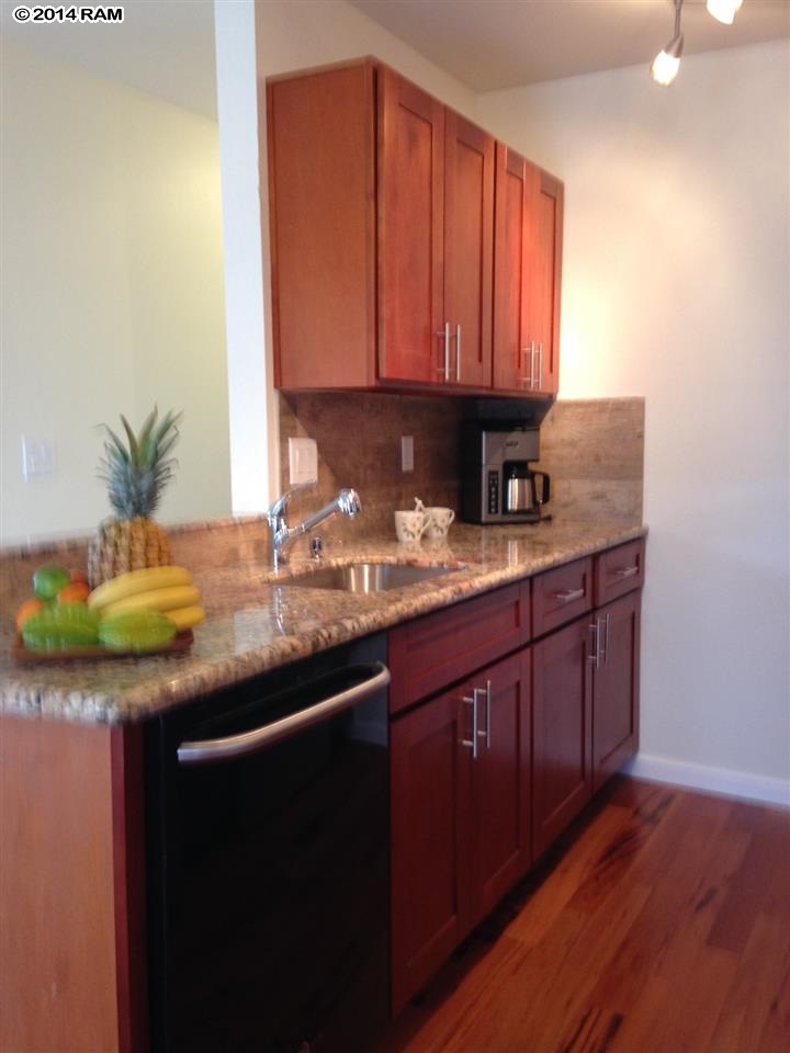 480 Kenolio Road, Unit 13204 Kihei, HI 96753 - Photo 5 of 18 a kitchen with granite countertop stainless steel appliances a sink and cabinets