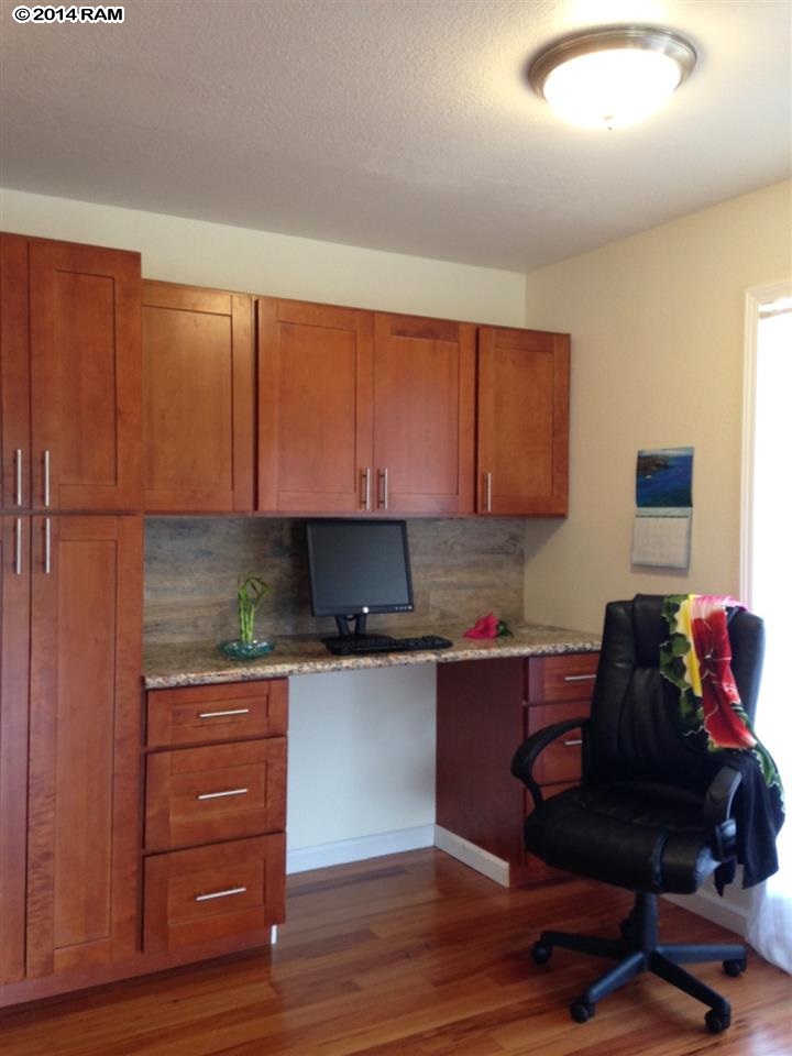 480 Kenolio Road, Unit 13204 Kihei, HI 96753 - Photo 6 of 18 a kitchen with granite countertop wooden cabinets and wooden floor