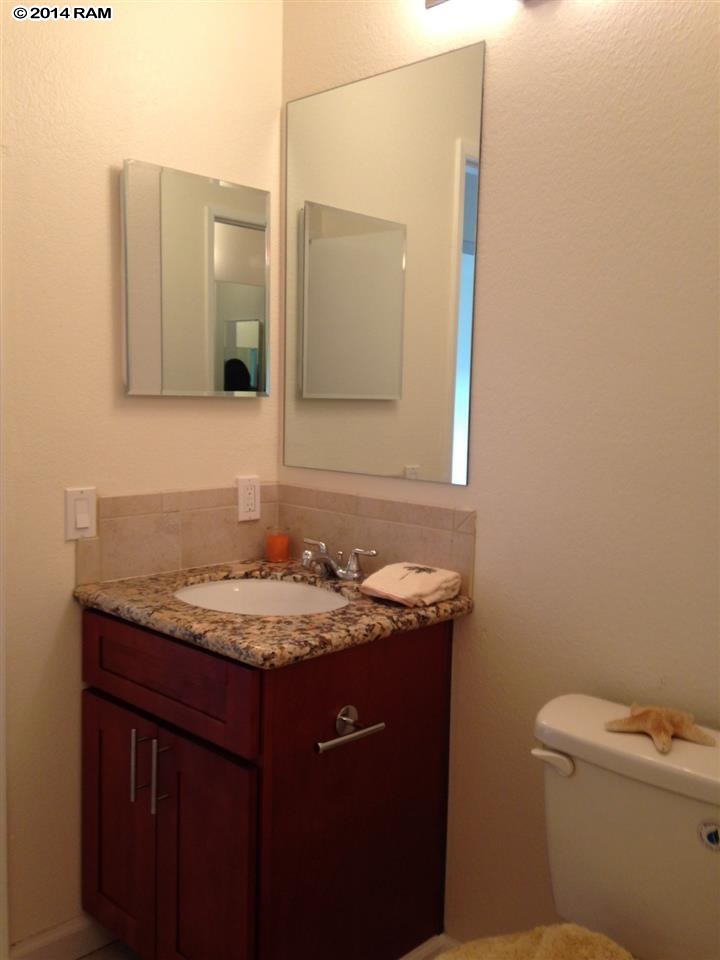 480 Kenolio Road, Unit 13204 Kihei, HI 96753 - Photo 8 of 18 a bathroom with a granite countertop sink and a mirror