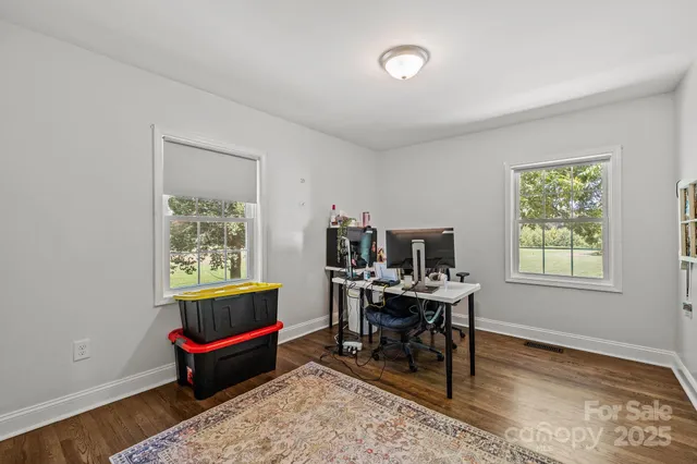 a work room with furniture wooden floor and a window