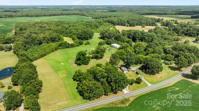 an aerial view of residential houses with outdoor space and trees