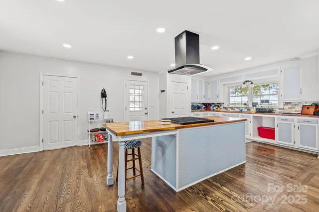 a kitchen with stainless steel appliances granite countertop a sink and a wooden floors
