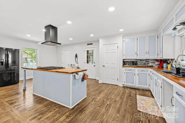 a large kitchen with stainless steel appliances granite countertop a stove and a refrigerator