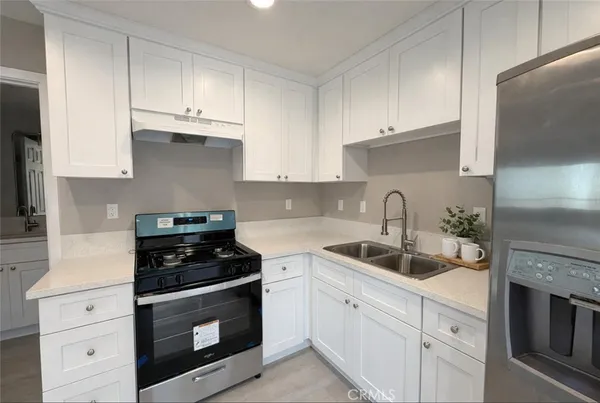 a kitchen with white cabinets and appliances